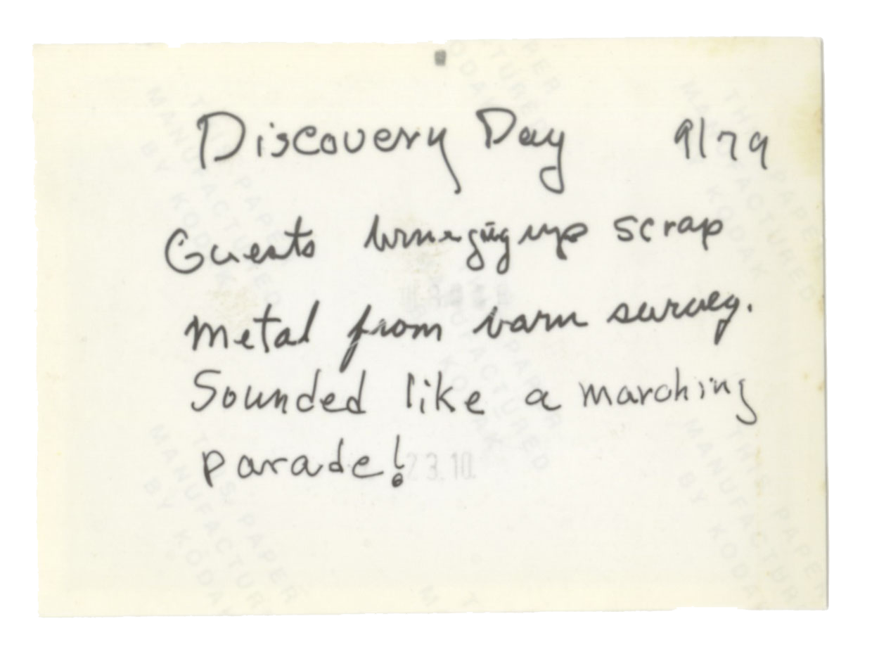 The back side of the photo shown above reads Discovery Day 9/79 Guests bringing up scrap metal from barn survey. Sounded like a
            marching
            parade! The text is handwritten.