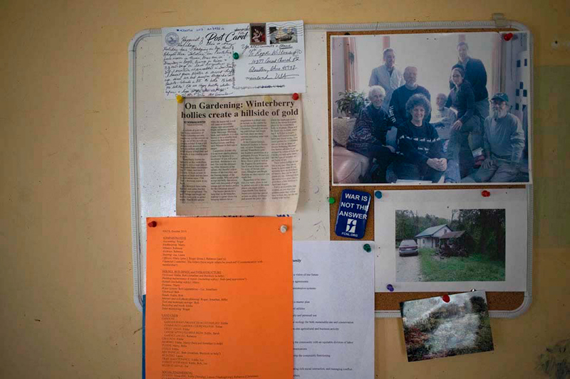 A bulletin board has several newspaper clippings and photos pinned to it.